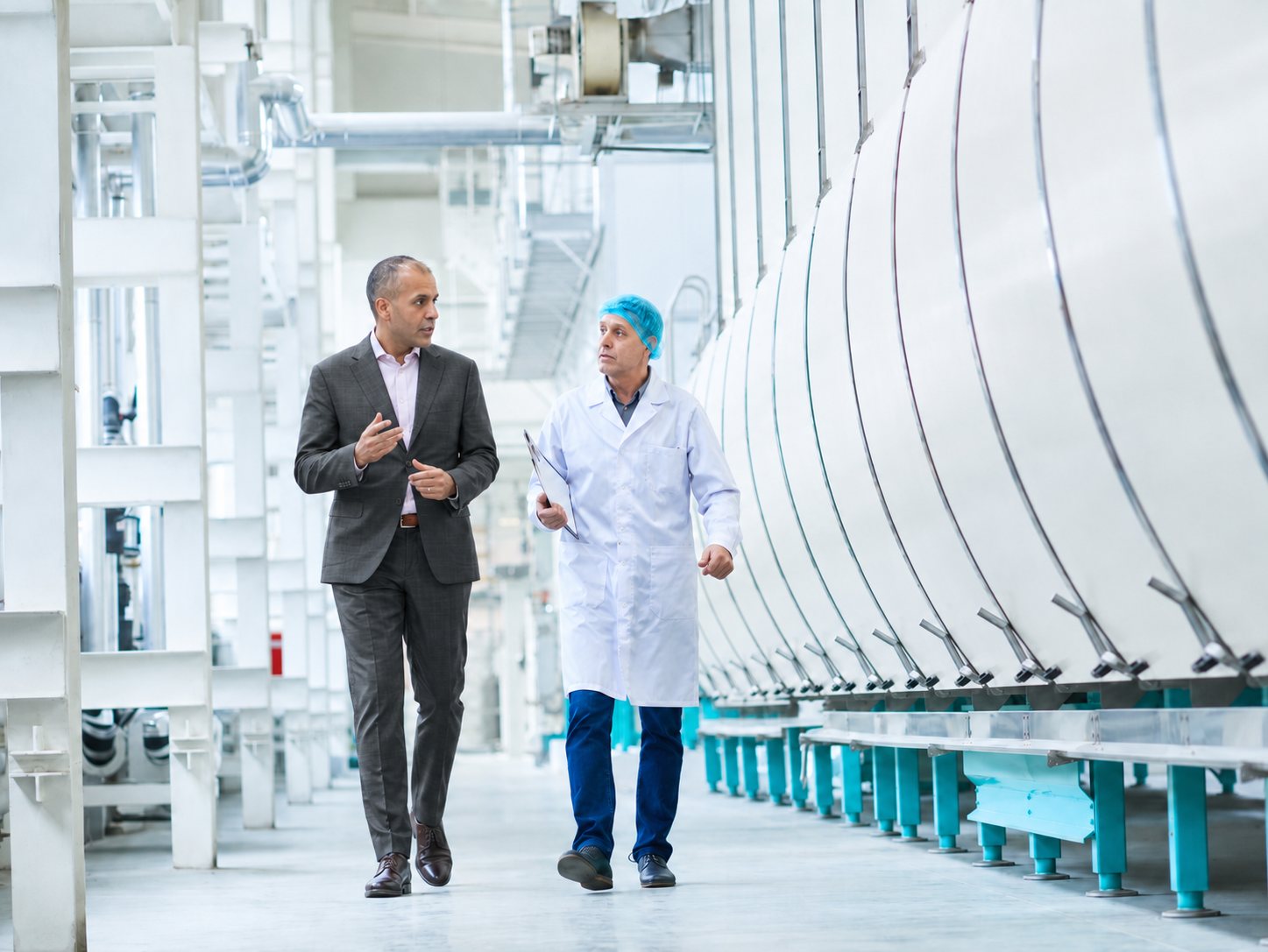 Consultant and technician walking an automated tablet manufacturing line